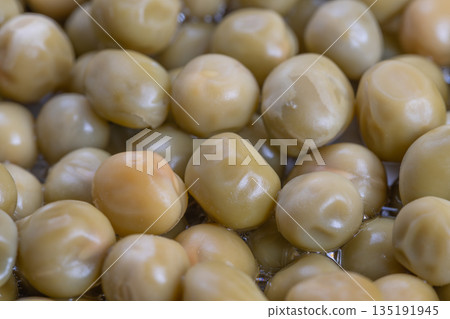 Macro shot highlighting pea skin details and reflections, Professional food photography capturing micro textures and moisture in canned peas with neutral background 135191945