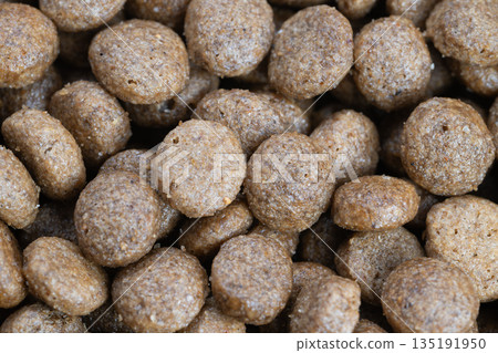 Feeding concept kibble ready for bowl, closeup pellets conveying flavor and crunch, versatile composition ideal for serving guides, pet owner education and portion visuals 135191950