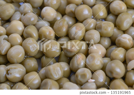 Canned peas as culinary decoration, Studio lighting highlights glossy pea spheres, Chef meticulously arranges canned peas with shine for attractive plated presentation 135191965