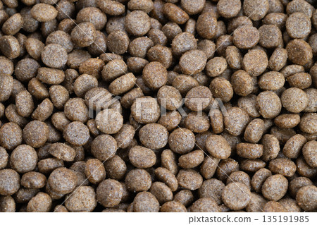 Highlighting glossy coating and dense pellets, Focusing on fine details of highquality feline treats, Emphasizing glossy finish and compact texture of gourmet cat food pieces 135191985