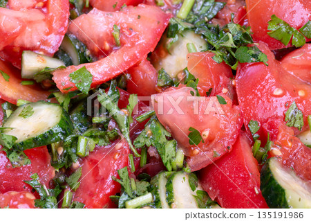 Fresh salad preparation, Vibrant mixture of chopped vegetables and lively textures, Casual kitchen scene showcasing colorful tomato and cucumber mixture with herbs and oil Fresh salad preparation, Vibrant mixture of chopped vegetables and lively textures, Casual kitchen scene showcasing colorful tomato and cucumber mixture with herbs and oil 135191986