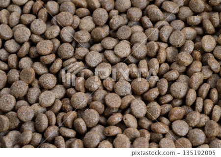 Closeup rustic wholegrain pet kibble showcasing uneven surfaces and grain flecks, evokes wholesome ingredients, sustainable sourcing messaging, warm natural palette 135192005