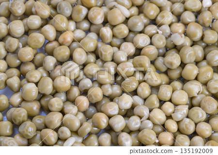 Colorful pea presentation, Detailed macro shot emphasizing pea texture and colorful highlights, Photograph capturing vivid coloration and glossy surface of fresh green peas 135192009