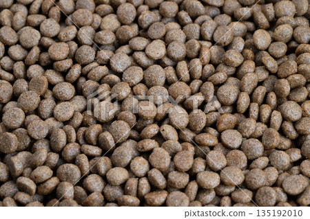 Closeup highprotein pet kibble emphasizing dense pellets and hearty texture, implies performance nutrition for active dogs, sporty branding potential, crisp focus 135192010