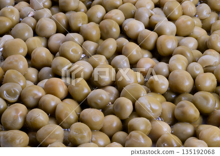 Industrial batch of canned peas on processing line, highvolume production, metal trays and conveyor context, ready for quality control and packaging, sterile factory atmosphere 135192068