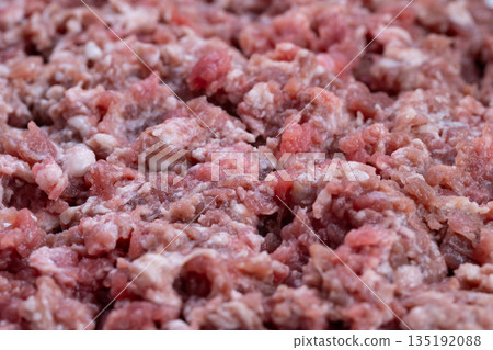 Homely ambiance with rich meat preparations, Closeup of minced beef forming hearty everyday meals, Vivid image of finely chopped raw meat as comforting kitchen staple Homely ambiance with rich meat preparations, Closeup of minced beef forming hearty everyday meals, Vivid image of finely chopped raw meat as comforting kitchen staple 135192088