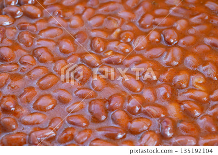 Outdoor smoky beans, Traditional campfire baked beans with smoky rustic aroma, Closeup of outdoorstyle baked beans simmered over fire with smoky hints and rustic charm 135192104
