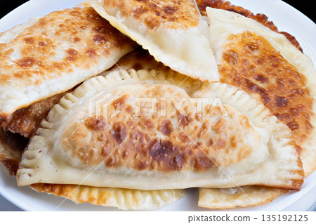 Fried chebureki crust detailed shot, Closeup of crispy chebureki with bubbles and browning, Highresolution image of fried chebureki highlighting texture and coloration Fried chebureki crust detailed shot, Closeup of crispy chebureki with bubbles and browning, Highresolution image of fried chebureki highlighting texture and coloration 135192125