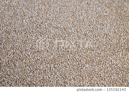 Abstract macro texture of white quinoa seeds used as creative background for advertising and editorial, tight focus on repeating grains, rhythmic visual and tactile appeal 135192143