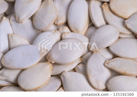 Seed shell imagery, Pumpkin seed shells with warm matte surfaces, Overlapping pumpkin seed shells display subdued shadows and warm earthy tones in rustic environment Seed shell imagery, Pumpkin seed shells with warm matte surfaces, Overlapping pumpkin seed shells display subdued shadows and warm earthy tones in rustic environment 135192160