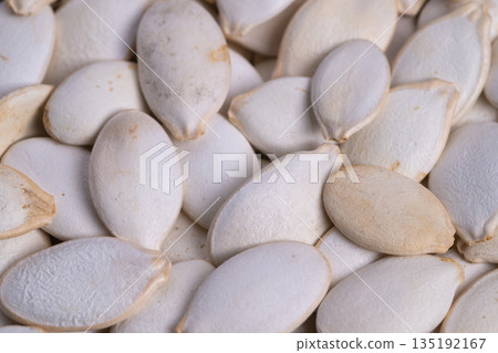 Closeup protein packed pumpkin seeds highlighting nutrition with fine powdery shells and clean composition for supplements, diet plans and smoothie bowl concepts Closeup protein packed pumpkin seeds highlighting nutrition with fine powdery shells and clean composition for supplements, diet plans and smoothie bowl concepts 135192167