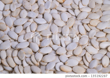 Bulk unprocessed pumpkin seeds prepared for packaging and distribution, Stacked pumpkin seeds designed for wholesale food service applications and retail distribution Bulk unprocessed pumpkin seeds prepared for packaging and distribution, Stacked pumpkin seeds designed for wholesale food service applications and retail distribution 135192287