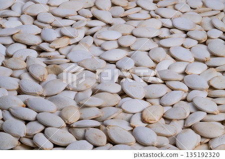 Glistening pumpkin seeds, Rustic backdrop with roasted hints, Warm tones evoke homemade pantry comfort, Artisan roasted pumpkin seeds on rustic wooden surface reflect craft quality Glistening pumpkin seeds, Rustic backdrop with roasted hints, Warm tones evoke homemade pantry comfort, Artisan roasted pumpkin seeds on rustic wooden surface reflect craft quality 135192320