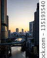 A view of a river flowing through a city and skyscrapers at dusk 135193540