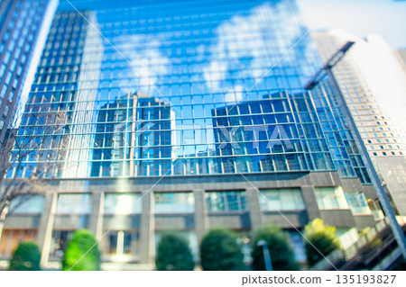 Buildings and sky reflected in the windows of an office building - Reverse tilt with a shift lens Buildings and sky reflected in the windows of an office building - Reverse tilt with a shift lens 135193827