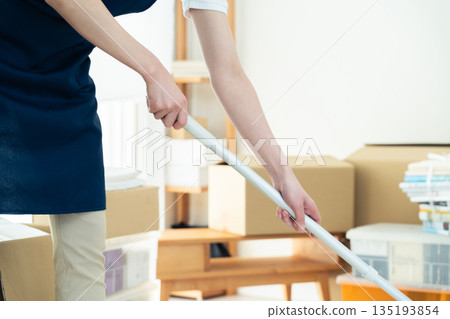 A woman tidying up and cleaning A woman tidying up and cleaning 135193854
