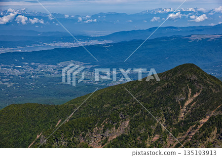 Lake Suwa and the snow-capped Yari and Hotaka mountain ranges seen from Yokodake in the Yatsugatake mountain range 135193913