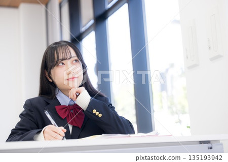 A girl thinking about her future plans, such as university entrance exams, in a classroom at a cram school, school, or prep school A girl thinking about her future plans, such as university entrance exams, in a classroom at a cram school, school, or prep school 135193942