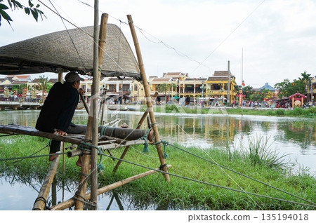 在越南會安旅遊勝地附近的一條河流上，人們使用漁網進行傳統捕魚。 135194018