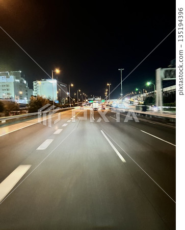 A motorway at night with city lights A motorway at night with city lights 135194396