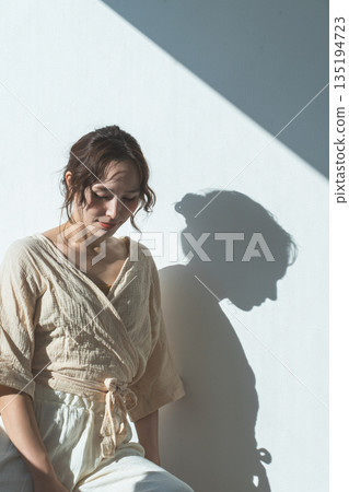 夕陽西下，窗邊站著一位女士（模特兒、時尚、光線、陰影） 135194723