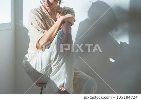 夕陽西下，窗邊站著一位女士（模特兒、時尚、光線、陰影） 135194724