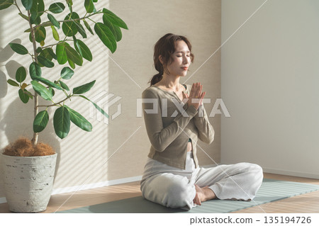 一位女士在自家客廳做瑜珈(放鬆、保健、冥想) 一位女士在自家客廳做瑜珈(放鬆、保健、冥想) 135194726