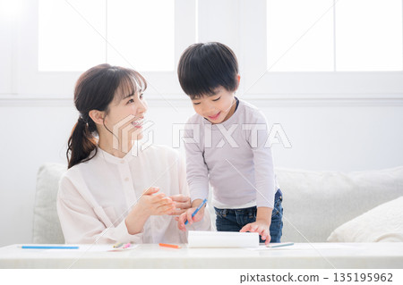 幼兒在母親的照顧下愉快地學習。母親表揚了他。 135195962