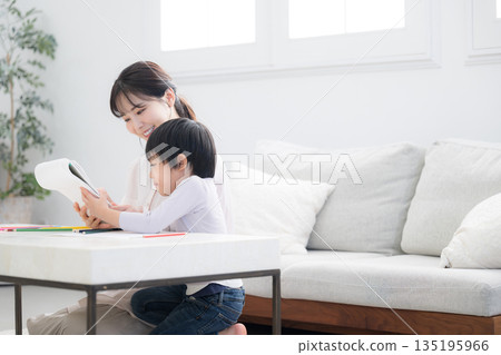 一個蹣跚學步的孩子在媽媽的照顧下快樂地學習。 135195966