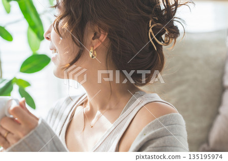 一位佩戴飾品、耳環和耳環的女性側臉 一位佩戴飾品、耳環和耳環的女性側臉 135195974