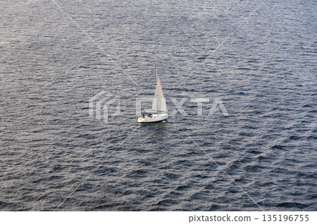 Aerial View of Solitary Sailboat on Expansive Ocean at Dusk Aerial View of Solitary Sailboat on Expansive Ocean at Dusk 135196755