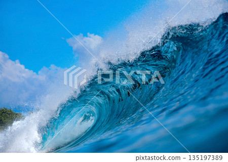 Clear Sky And Sharp Sunlight Illuminate Massive Turquoise Coastal Wave In Motion Clear Sky And Sharp Sunlight Illuminate Massive Turquoise Coastal Wave In Motion 135197389