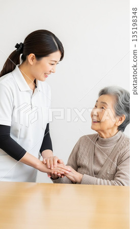 微笑的護理員和老婦人手牽手 微笑的護理員和老婦人手牽手 135198348