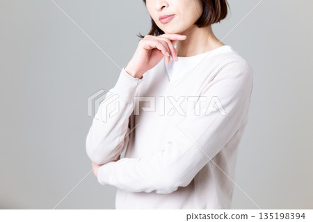 身穿休閒針織衫的中年婦女，神情憂慮 135198394