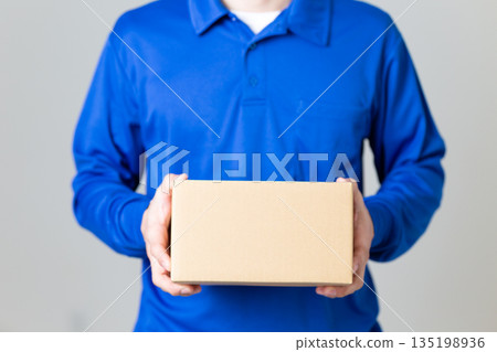一名物流運輸業的男子拿著一個紙箱 135198936