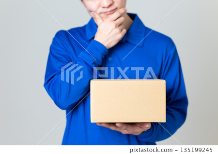 A man in the logistics and transportation industry worried about a cardboard box 135199245