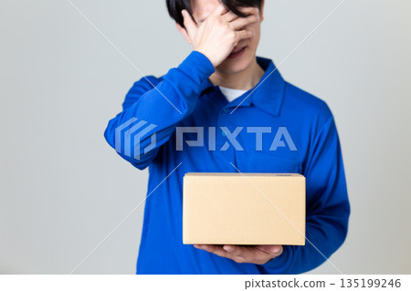 A man in the logistics and transportation industry worried about a cardboard box A man in the logistics and transportation industry worried about a cardboard box 135199246