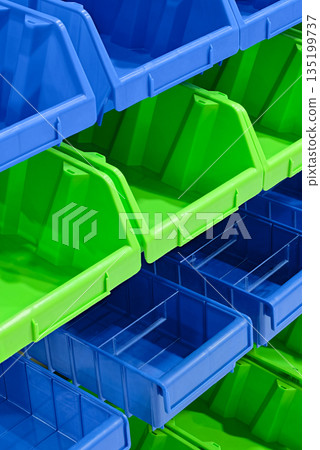 Blue and green plastic drawers for small items of the workshop storage system 135199737