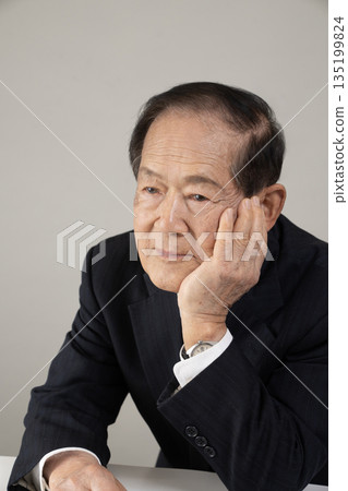 Bust enhancement of a senior man resting his chin on his hand 135199824