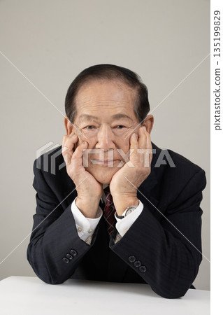 Bust enhancement of a senior man resting his chin on his hand 135199829