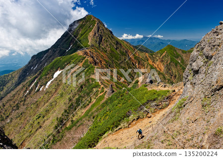 Summer Yatsugatake mountain range: Climbers walking along the Yokodake ridgeline and clouds rising from Akadake Summer Yatsugatake mountain range: Climbers walking along the Yokodake ridgeline and clouds rising from Akadake 135200224