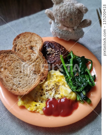 A delightful brunch spread featuring a mix of savory and sweet dishes, including fresh pastries, eggs, seasonal fruits, and a hot beverage. A perfect mid-morning indulgence. 135200418