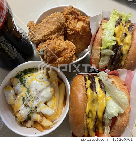 Juicy and flavorful burger paired with crispy, golden fried chicken. A perfect combination of savory, crunchy, and satisfying textures for the ultimate comfort food experience. 135200701