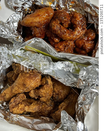 Crispy Korean fried chicken, perfectly glazed with a sweet and spicy sauce. Ideal for food photography and menus, showcasing the irresistible crunch and flavor of this beloved dish. 135200711