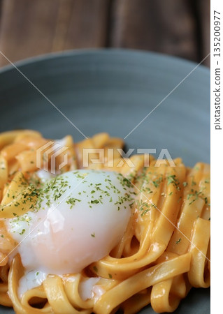 Rich shrimp cream pasta with flat noodles topped with a soft-boiled egg Rich shrimp cream pasta with flat noodles topped with a soft-boiled egg 135200977