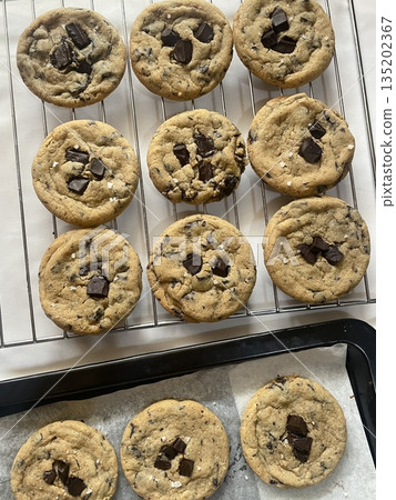 Freshly baked cookies with a golden-brown finish and chocolate chips. Perfectly crisp on the edges with a soft center, offering a delicious, comforting treat for any occasion. Freshly baked cookies with a golden-brown finish and chocolate chips. Perfectly crisp on the edges with a soft center, offering a delicious, comforting treat for any occasion. 135202367