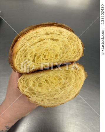 A croissant is a classic French pastry known for its buttery, flaky layers and golden crust. Often enjoyed plain or filled with chocolate, almond, or ham and cheese, it’s a perfect for breakfast 135202420