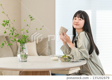 正在減肥的年輕亞洲女性早餐吃沙拉和酸奶 正在減肥的年輕亞洲女性早餐吃沙拉和酸奶 135202879