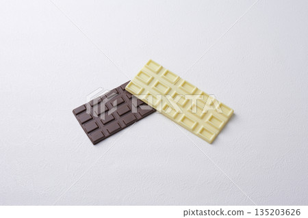 白色和棕色的巧克力棒擺放在白色背景上的盤子上 135203626