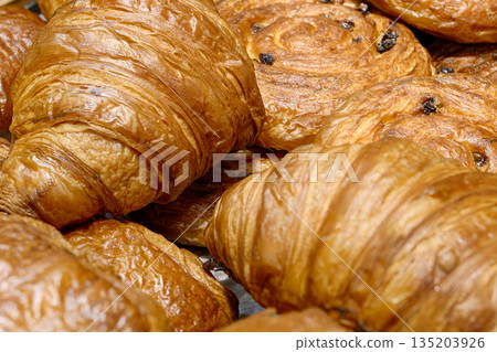 Various types of traditional pastries made from puff pastry - croissants and buns with raisins 135203926